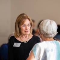 Donna Brooks chatting with another woman at event, who is facing away from the camera